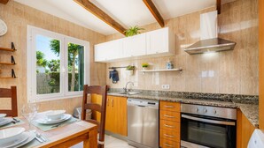 Una cocina moderna con armarios de madera, horno empotrado y lavavajillas.