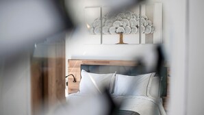 Une chambre à coucher avec un lit, une tête de lit et une œuvre d’art accrochée au mur.