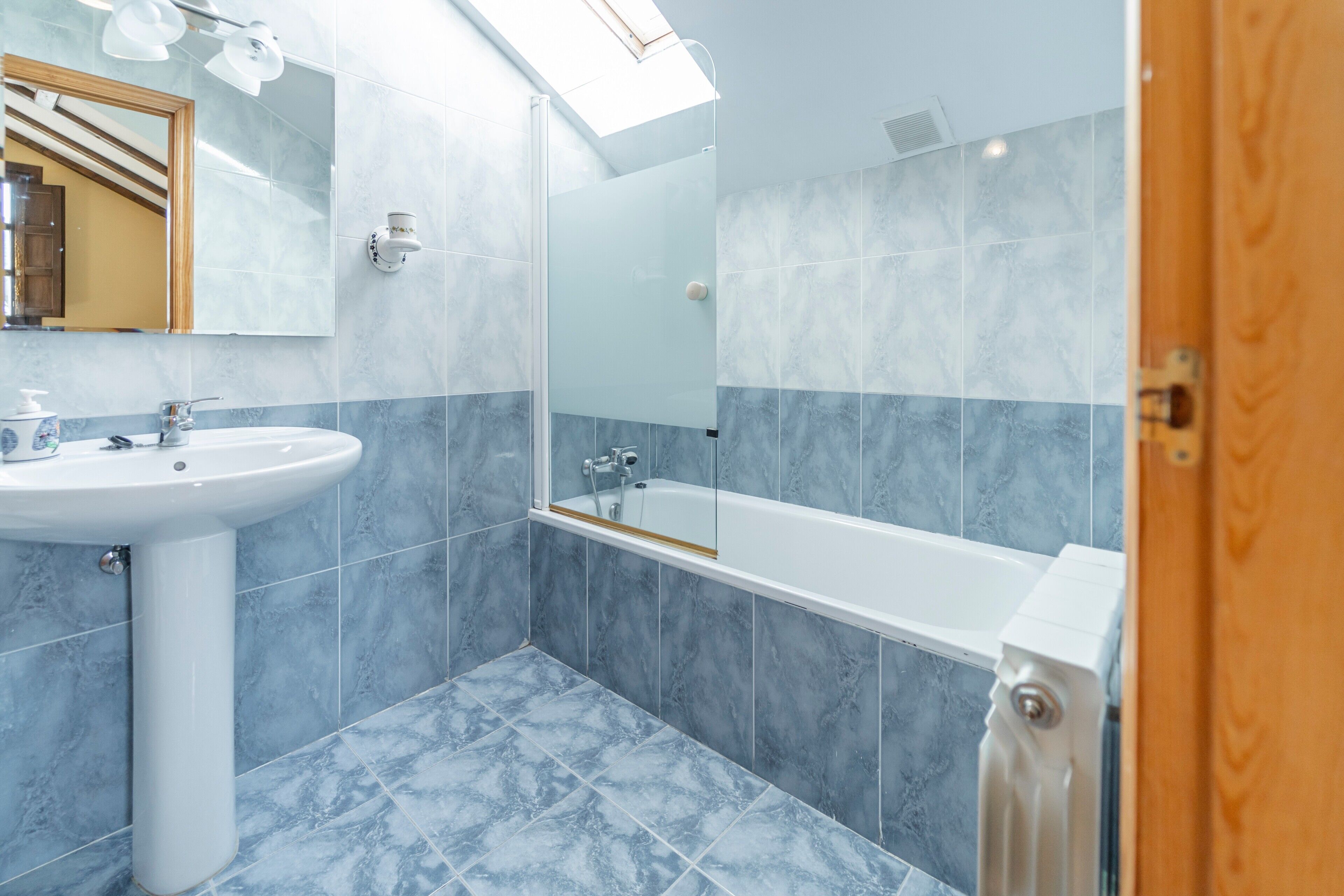 Une salle de bain avec un lavabo, un miroir et une baignoire.