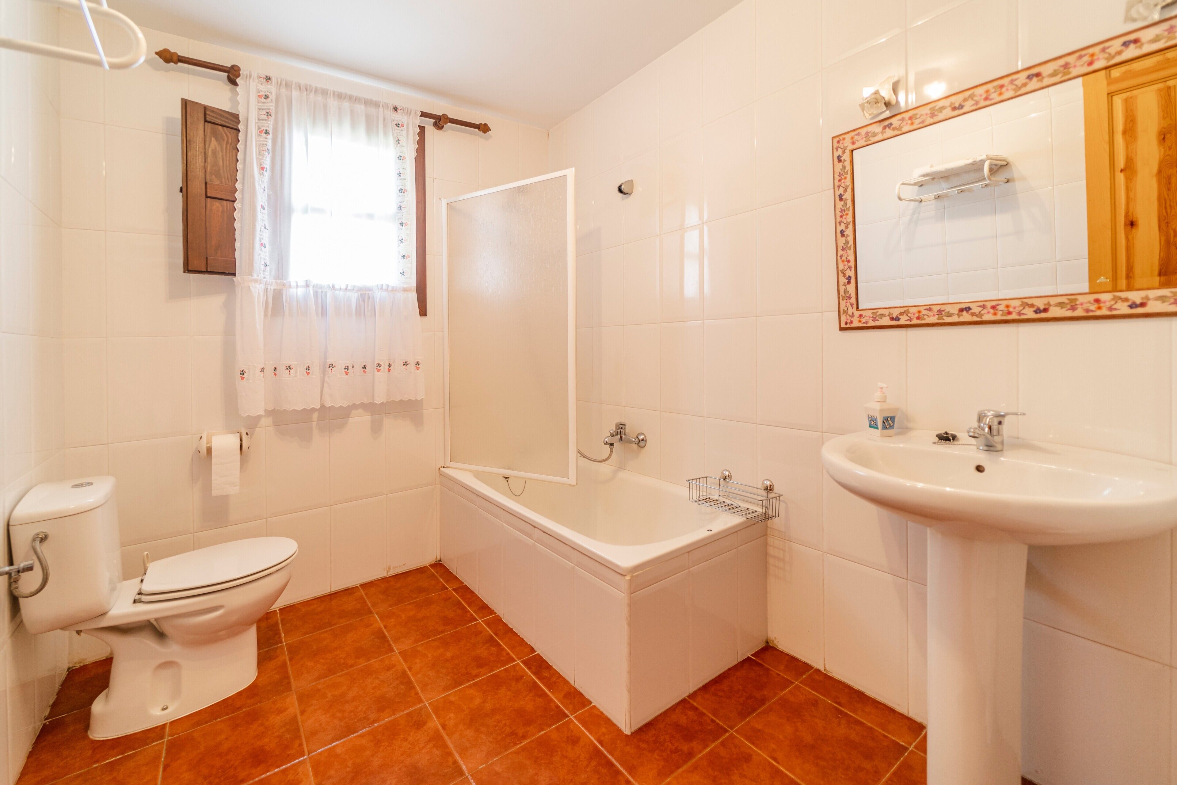 A bathroom with a toilet, bathtub, shower, and sink.