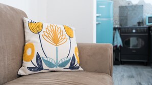 A beige sofa with a decorative pillow featuring a floral pattern. - Apartment 'S' Istancu Vetzu' with Mountain View, Wi-Fi and Air Conditioning (Irgoli)