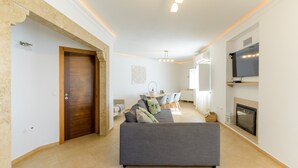 Ein modernes Wohnzimmer mit einer Couch, einem Fernseher und einem Kamin.