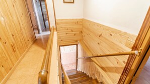 Een houten interieur met een trap en een deur naar een andere kamer.