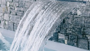 A stone wall with a waterfall feature.