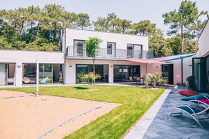 Un edificio moderno con techo plano, ventanas grandes y un balcón.