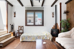 A room with a bed, a fireplace, a wooden chair, and a staircase. - Villa Canijo Barbate – Beach House with Private Terrace (Barbate)