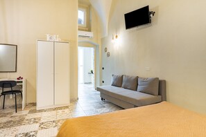 Une chambre à coucher avec un lit, un canapé, un bureau et une armoire.