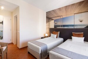 Une chambre d’hôtel avec deux lits, une vue sur l’océan, un plafond en bois et un sol carrelé.