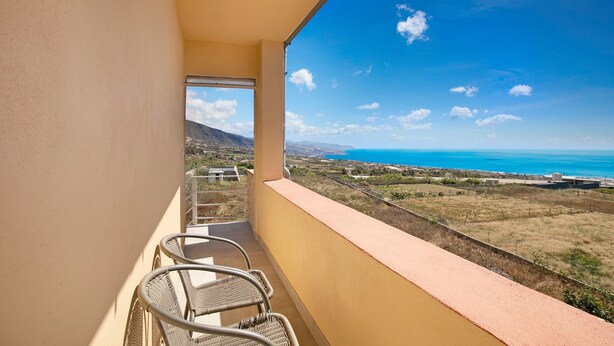 A balcony with wicker chairs, a view of the sea, and a distant landscape. - Vacation Apartment 'Fewo Arafo' with Sea View, Private Terrace and Wi-Fi (Güímar)