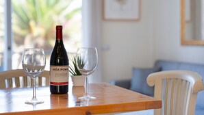 Une table en bois avec une bouteille de vin et deux verres.