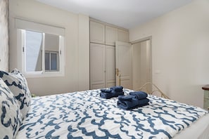 Um quarto com uma cama, uma janela e um guarda-roupa.