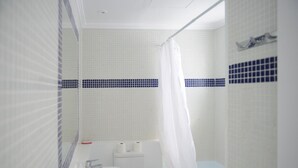 Un bany amb vàter, rentamig i zona de dutxa.