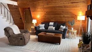 A cozy living room with a wooden ceiling, a sofa set, a leather armchair, and a small side table with a lamp. - Dock Holiday - beautiful views on Badin Lake.  Updated kitchen & game room (New London)