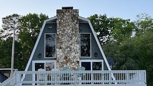 A modern house with a stone facade, a balcony with white railings, and a grassy yard. - Dock Holiday - beautiful views on Badin Lake.  Updated kitchen & game room (New London)