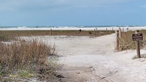 Ein Strandweg, der zum Meer führt, mit einem Schild, das Restaurierungsarbeiten an Strandhafer zeigt.