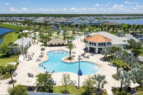 Un complejo turístico con una piscina central grande, varias piscinas más pequeñas y diversas zonas de estar al aire libre.