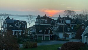 Un quartier résidentiel avec des maisons, une route et une étendue d’eau en arrière-plan.