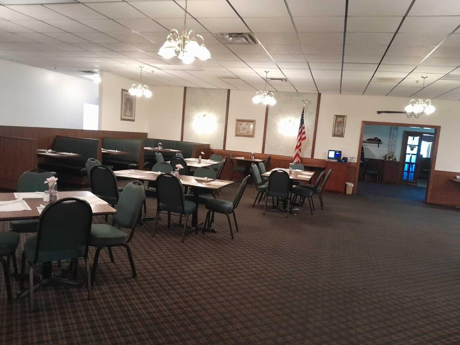 A conference room with tables and chairs, a flag, and a reception desk.