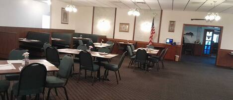 A conference room with tables and chairs, a flag, and a reception desk.
