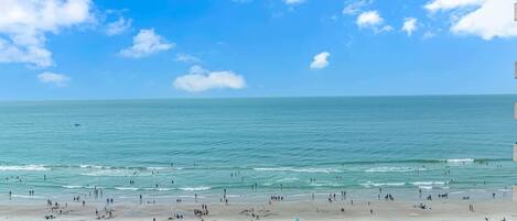 A beach with umbrellas and people.