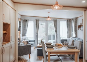 A dining area with a table, chairs, and a hanging light fixture. - 2 bedroom accommodation in Bridgnorth (Bridgnorth)