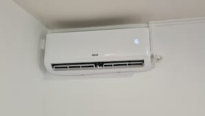 A white air conditioning unit mounted on a wall with a digital display showing the number 16. - Fully furnished and air-conditioned apartment (Les Abymes)