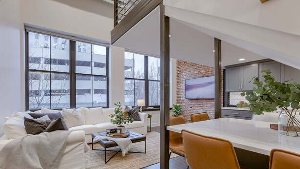 Una sala de estar moderna con sofá, mesa de centro y comedor.