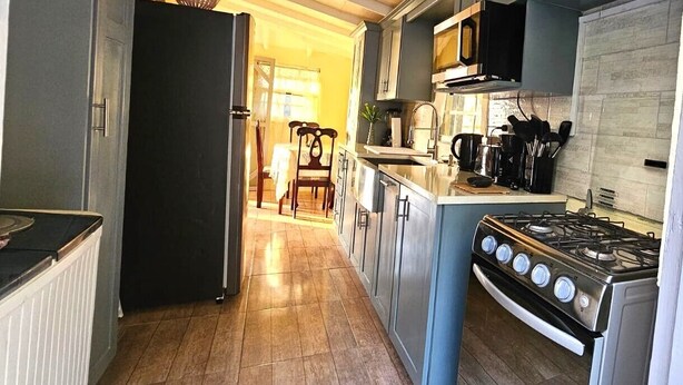 Une cuisine équipée d’une cuisinière, d’un four à micro-ondes et de placards.