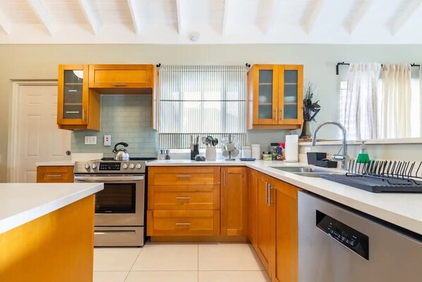 Une cuisine moderne avec des meubles en bois, des appareils électroménagers en acier inoxydable et un lave-vaisselle.