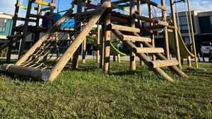 Estructura de juegos con toboganes y elementos para escalar, sobre un cielo azul despejado.