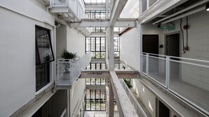 Un atrium à plusieurs niveaux, doté d’un espace central ouvert, de rampes et d’un escalier.