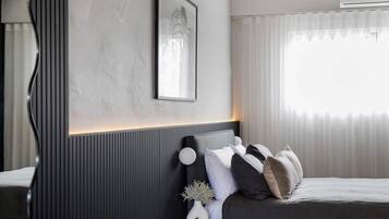 A modern bedroom with a bed, bedside table, and a framed picture on the wall.