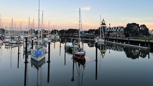 A marina with multiple boats docked, calm water, and a small building with a dome roof. - Kensington Motel (Whangarei)