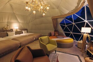 A tented accommodation with a bed, seating area, and a large window. - Akazawa Onsen Hotel (Ito)
