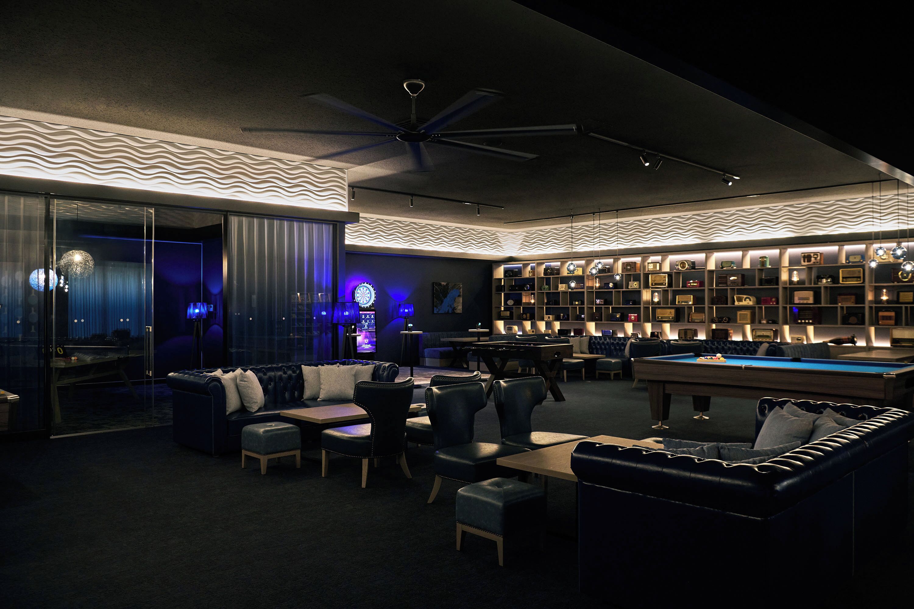 A modern lounge area with a pool table, comfortable seating, and a wall of framed items.