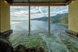 Una fuente termal con vistas al mar y a las montañas.