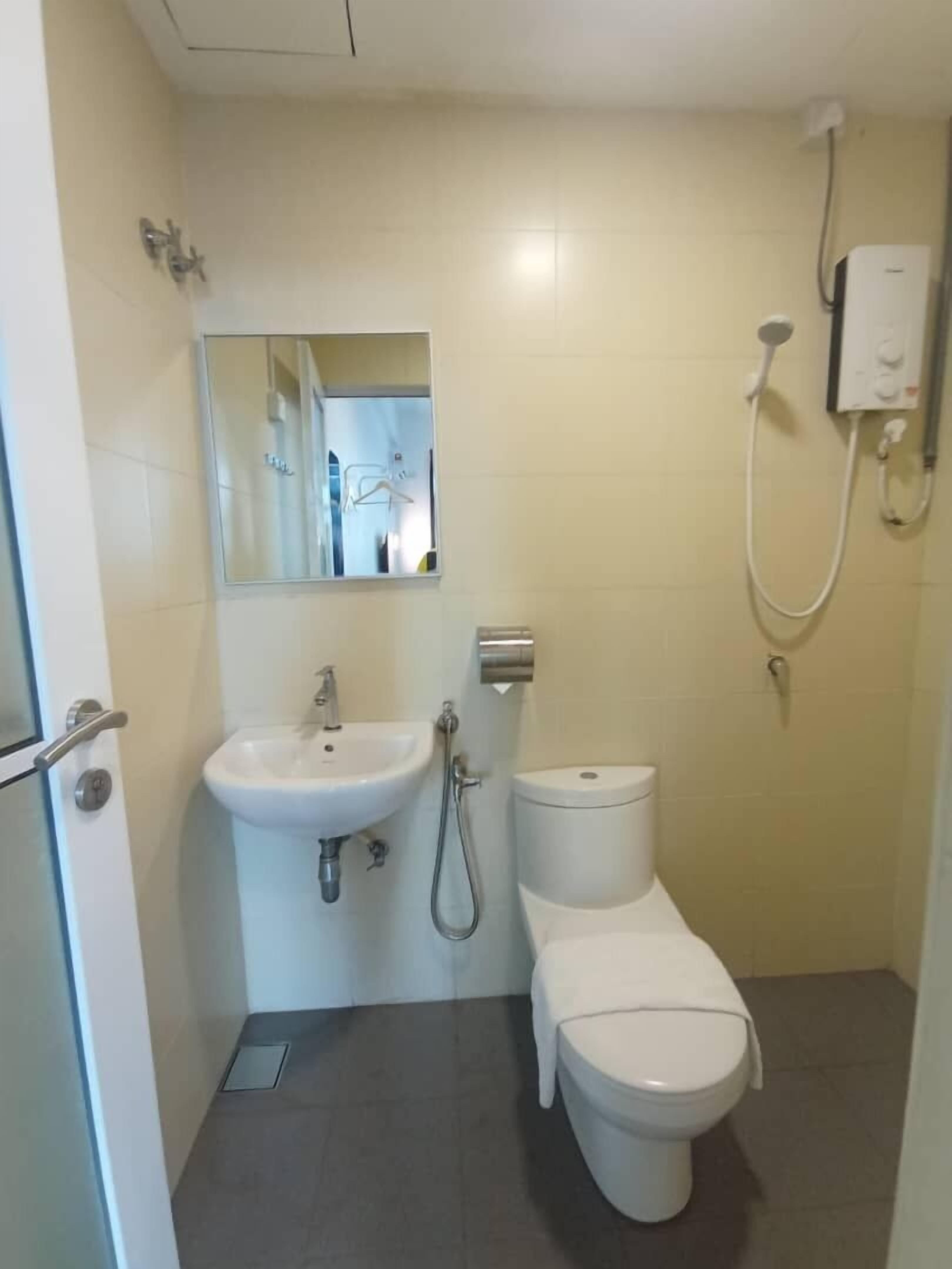Un baño pequeño y funcional con un lavamanos blanco, un inodoro y una ducha.