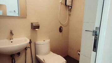 A small bathroom with a sink, toilet, and shower.