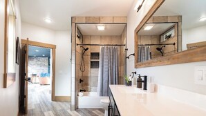 A modern bathroom with a shower, toilet, and vanity.