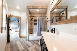A modern bathroom with a shower, toilet, and vanity.