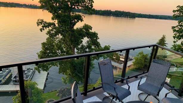 Eine Terrasse mit Sitzgelegenheit und Feuerstelle mit Blick auf einen See.
