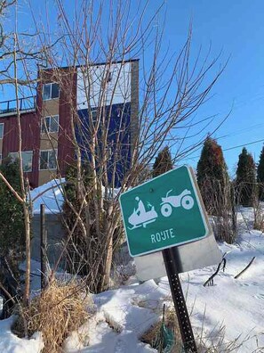 A sign indicating a ski route with a snowmobile symbol.