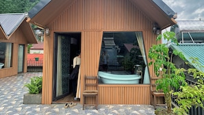 A wooden building with a large window and a small outdoor seating area. - Alley House (Sa Pa)
