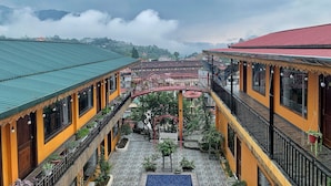 A courtyard with a red bridge, potted plants, and a blue tiled area. - Alley House (Sa Pa)