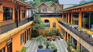 A courtyard with multiple balconies, potted plants, and a central archway. - Alley House (Sa Pa)