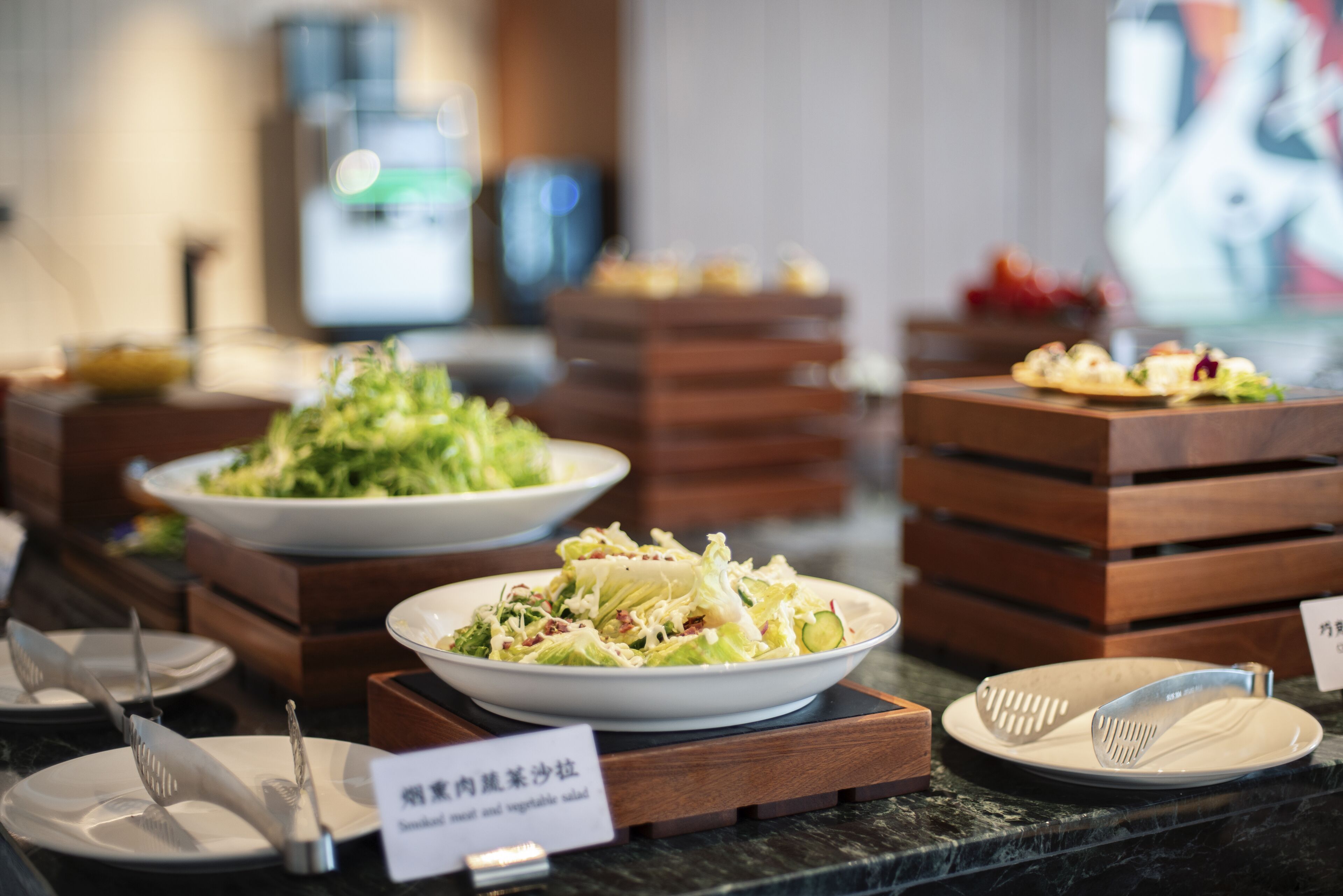 A buffet with various dishes, including a salad, arranged on wooden stands.