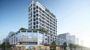 Ein modernes Hotel mit einzigartigem architektonischen Design, das durch ein markantes Eckgebäude mit einer rasterförmigen Fassade und einer flachdachigen Struktur mit großen Fenstern besticht.