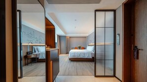 Une chambre d’hôtel moderne dotée d’un grand lit, d’un bureau et d’un coin salon.
