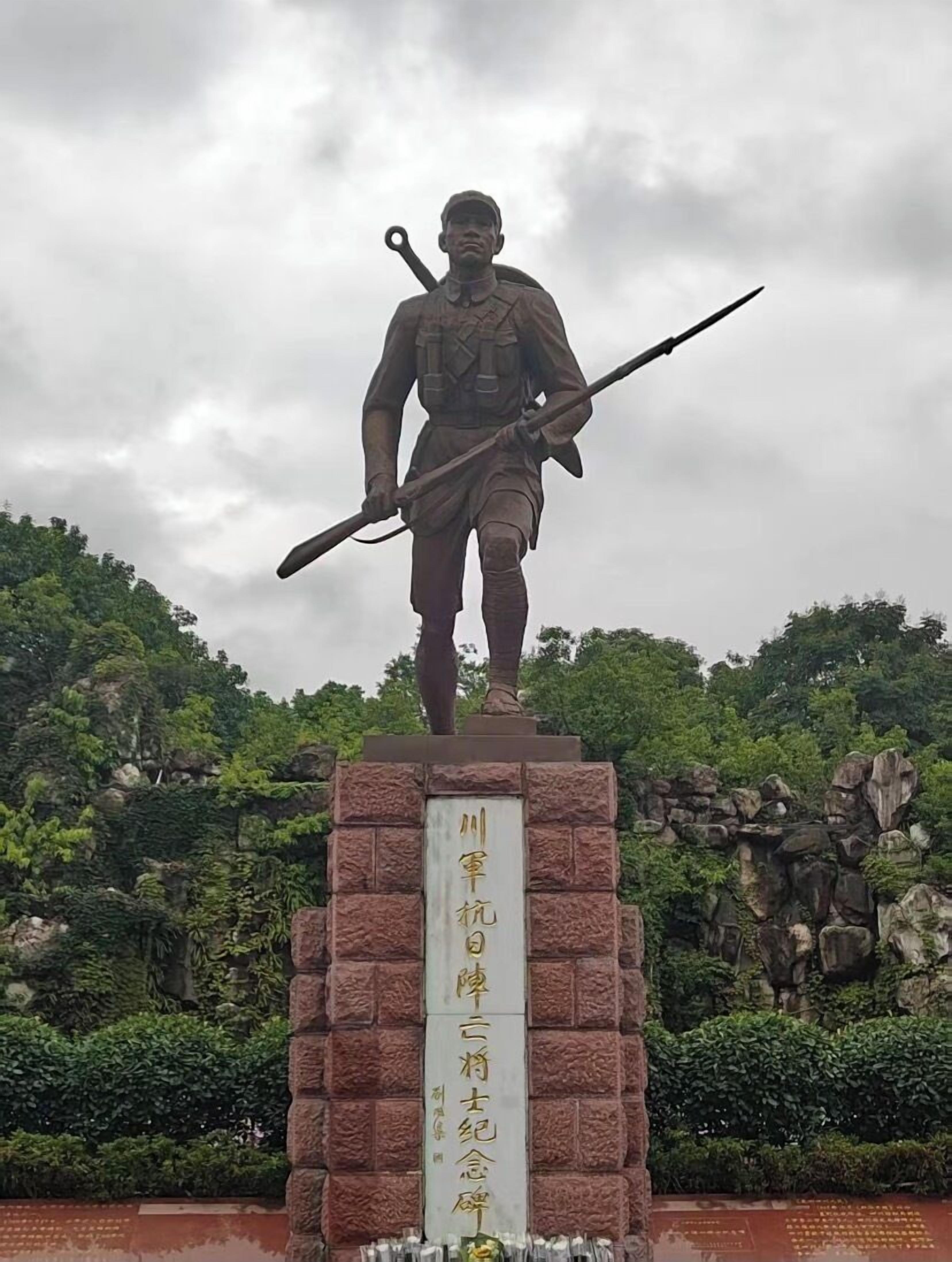 A statue of a soldier holding a rifle and a bayonet, mounted on a stone pedestal with a plaque.