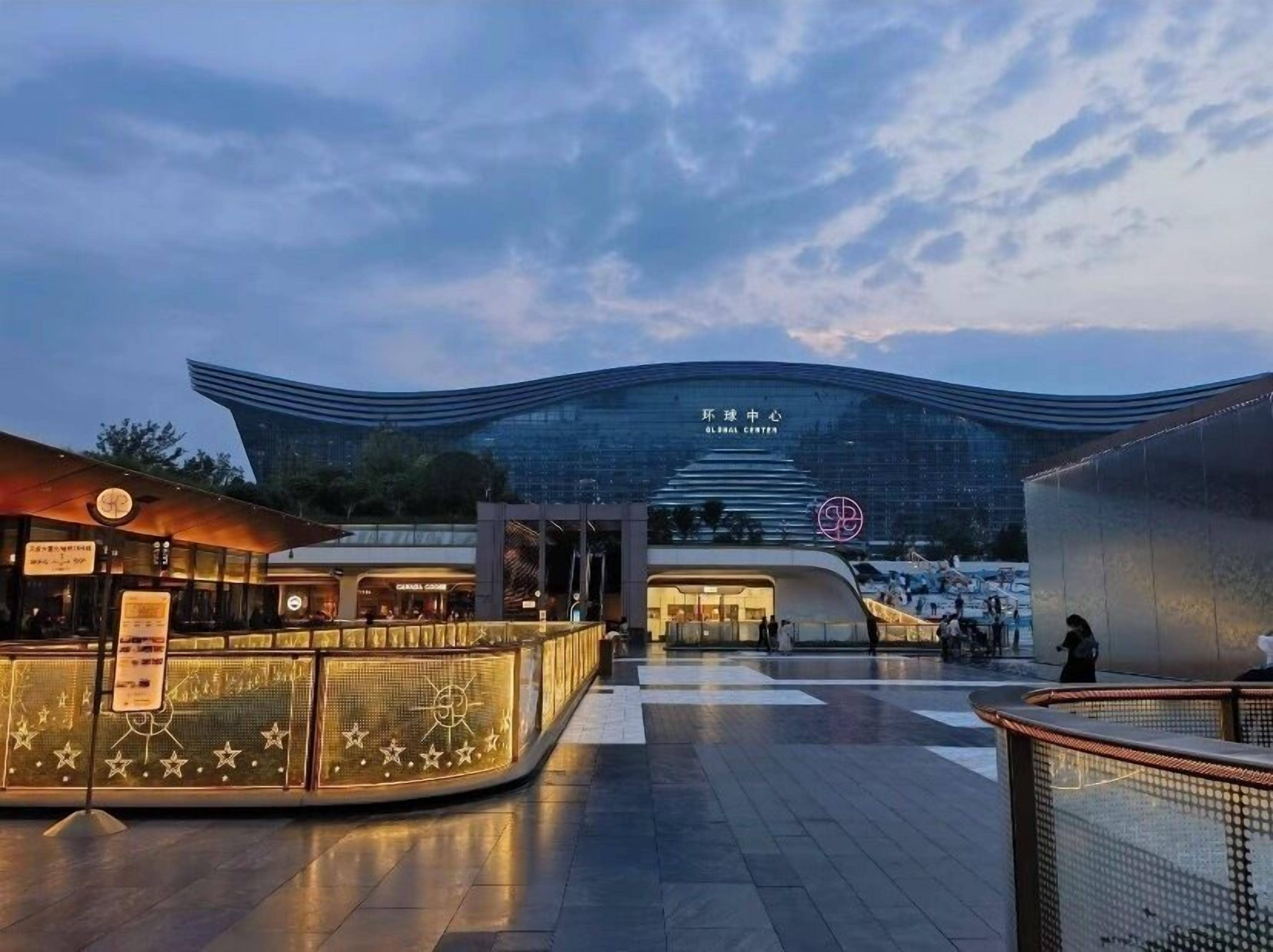 Ein modernes Gebäude mit einer gewölbten Fassade und einem Schild mit der Aufschrift 'Global Center'.